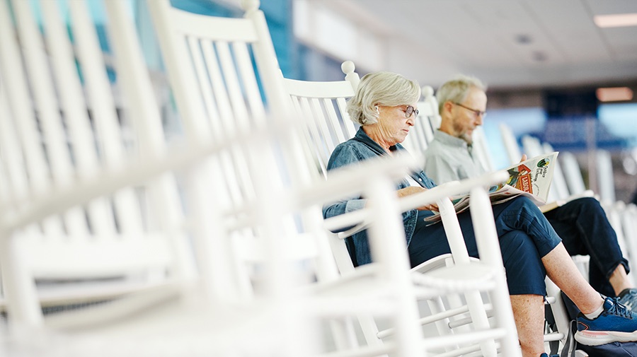 Travelers relaxing in white rocking chairs in the BTV Skyway